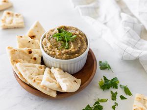 Baba ganoush in a bowl with pita bread wedges
