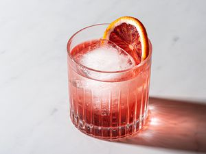 Blood Orange Negroni in a glass, garnished with a slice of blood orange 