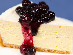 A slice of cheesecake with blueberry compote