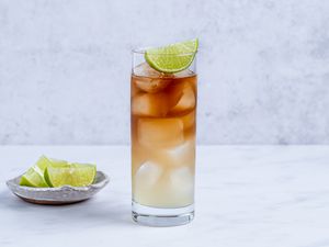 Dark 'n Stormy Mocktail in a glass, garnished with a lime wedge 