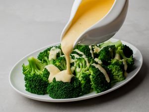 Easy cheddar cheese sauce poured over broccoli florets