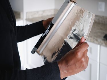 person removing aluminum foil from roll