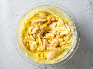 Saffron chicken pieces marinating in yogurt mixture
