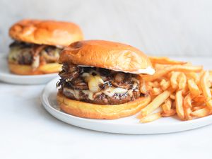 mushroom swiss burger with fries on a plate