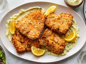 Panko-crusted oven-fried haddock on a plate with orange slices