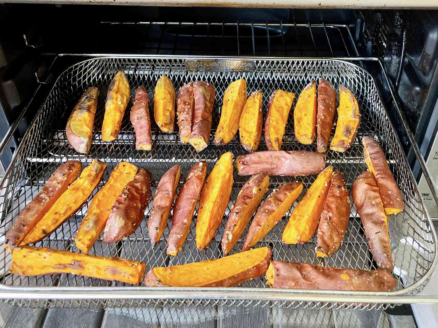 A metal basket of potato wedges in the Breville Smart Oven Air Fryer