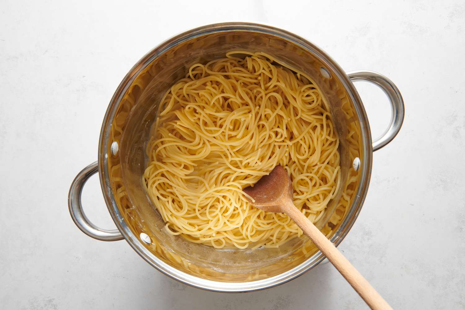 A pot of cooked spaghetti in a cream cheese-pasta water sauce