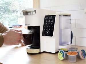 bruvi coffee brewer with brewed coffee in glass mug in tester's hand