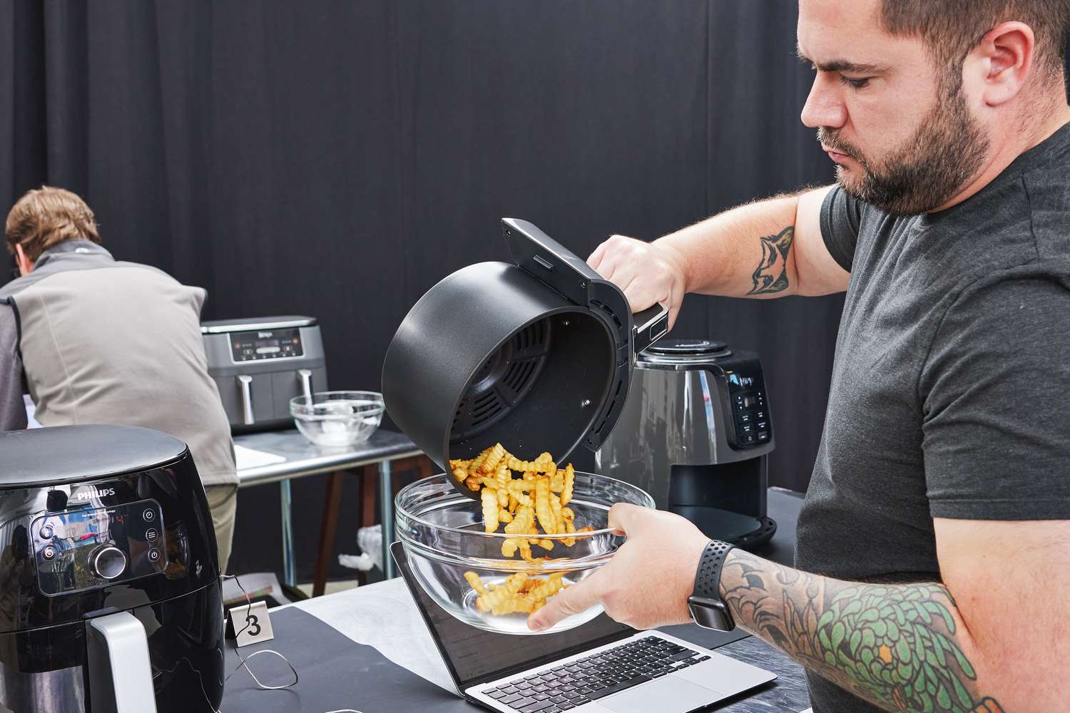 Person pouring fries into a bowl from the Ninja AF101 Air Fryer