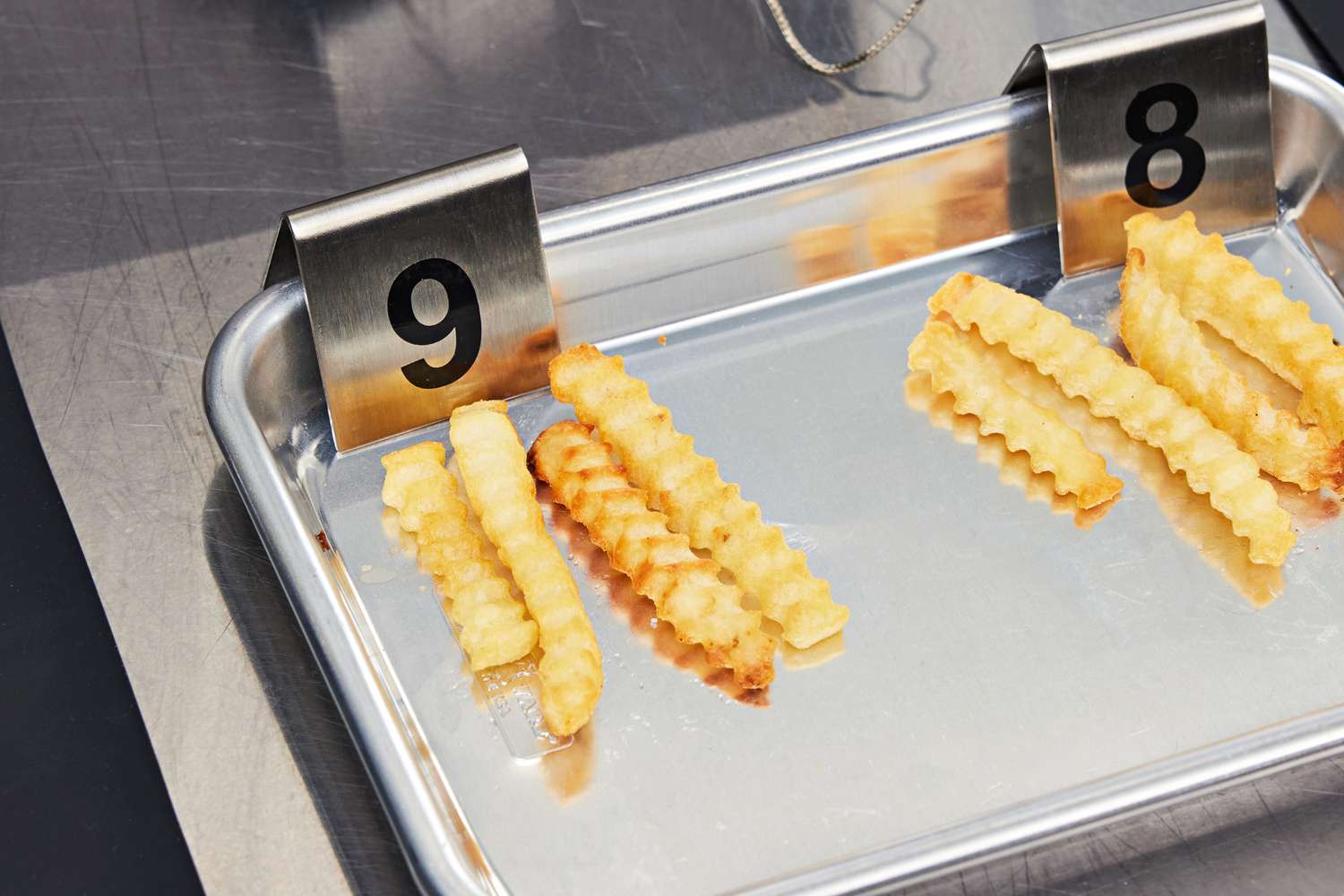 A small baking sheet with two groups of fries 