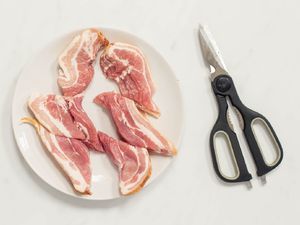 plate of bacon with kitchen scissors