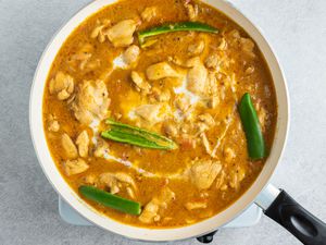 South Indian-Style Chicken Curry with green chiles in a pan 