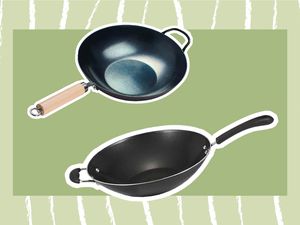 Two woks displayed on a green and white striped background